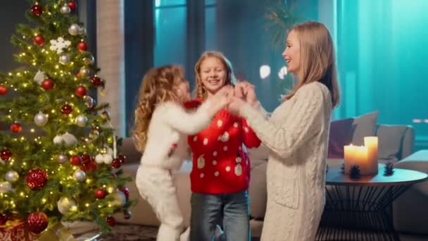 Ευτυχισμένη μητέρα παίζει με τις κόρες κοντά στο χριστουγεννιάτικο δέντρο — Αρχείο Βίντεο