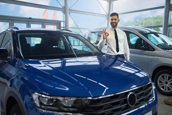 Omul de afaceri semnează OK în timp ce stă la salonul auto — Fotografie, imagine de stoc