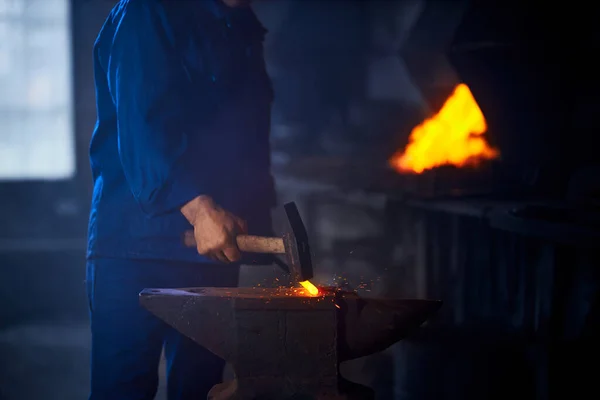 Detailní záběr muže bít kladivem na zářící horký kov — Stock fotografie