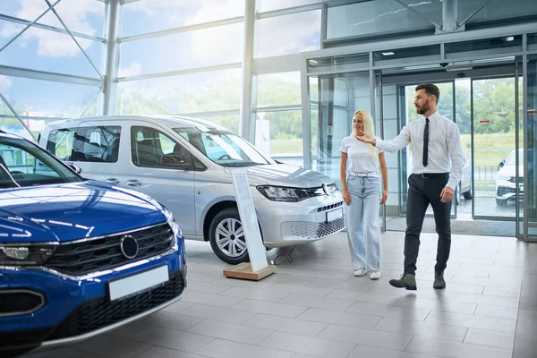 Vendedor ayudando a cliente femenino a comprar coche nuevo —  Fotos de Stock