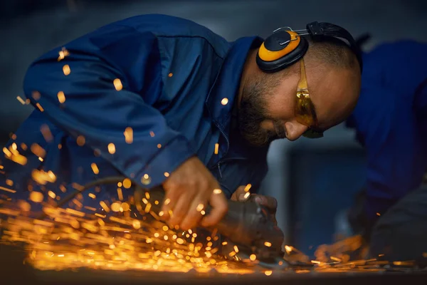 Pracovník lešticí kovový produkt pomocí úhlové brusky — Stock fotografie