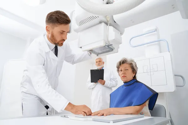 Asistent připravuje starého pacienta na diagnostickou ruku ultrazvukem. — Stock fotografie