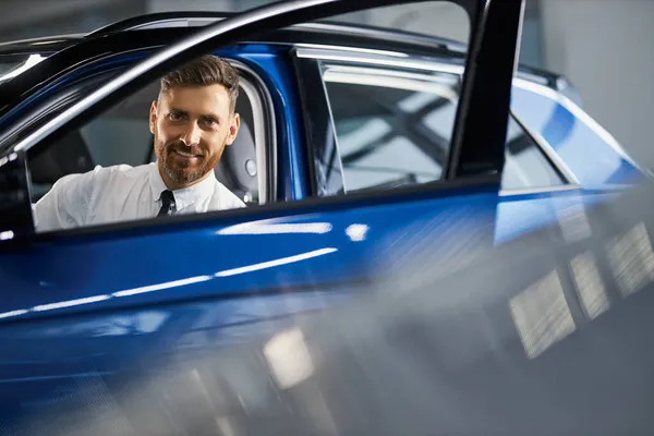 Beau homme d'affaires achetant une nouvelle voiture au showroom automobile — Photo