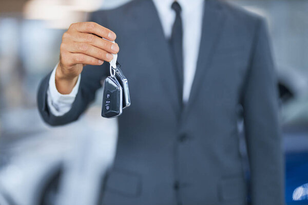 Close up of man holding keys from new modern car