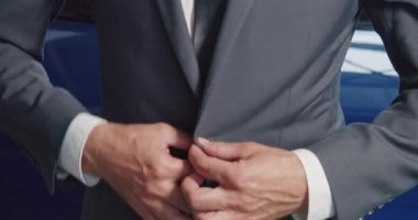 Araba kuaföründe dikilirken ceketinin düğmelerini ilikle.