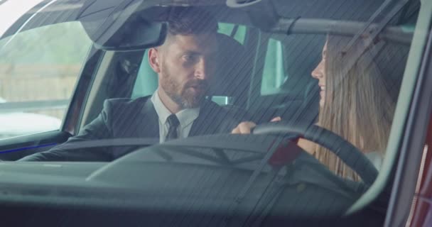 Salesman показує жіночий клієнтський салон нового сучасного автомобіля — стокове відео