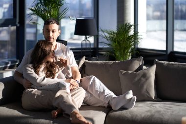 Güzel, beyaz bir çift rahat koltukta sarılıyor.