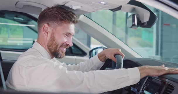 Uśmiechnięty mężczyzna siedzi w nowym samochodzie i pokazuje kciuk w górze — Wideo stockowe