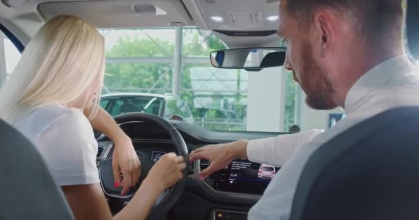 Salesman showing interior of new car to female customer — Stock Video