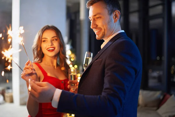 Paar genießt Heiligabend mit Wunderkerzen und Champagner — Stockfoto