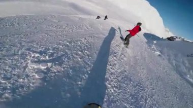 Yokuş aşağı giden snowboardcular.