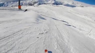 Kayakçı elinde kamerayla yamaçta geziyor..