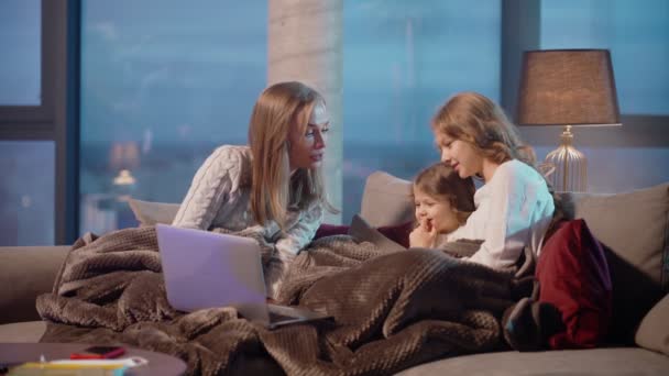 Мать с двумя дочерьми, имеющие видео-звонок на ноутбуке — стоковое видео