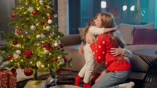 姉妹抱擁彼らのお母さん近クリスマスツリーにホーム — ストック動画