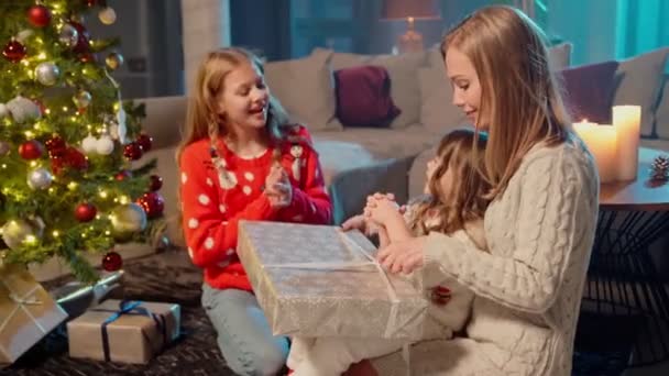 Hermanas alegres abriendo regalos de Navidad con su madre — Vídeo de stock