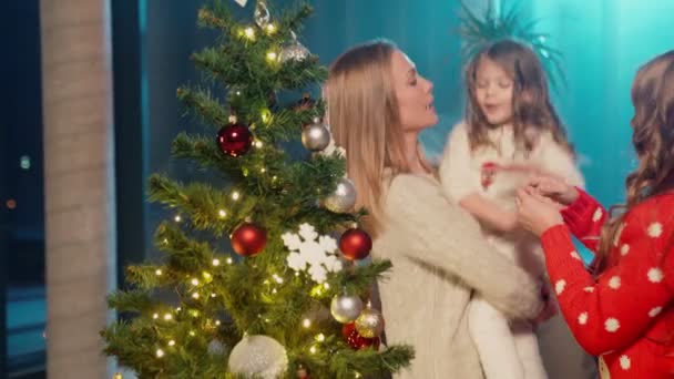 Ευτυχισμένη μητέρα στολίζει χριστουγεννιάτικο δέντρο με δύο κόρες — Αρχείο Βίντεο