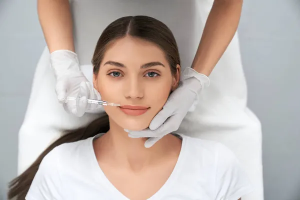 Vrouw liggend op procedure voor lipvergroting. — Stockfoto