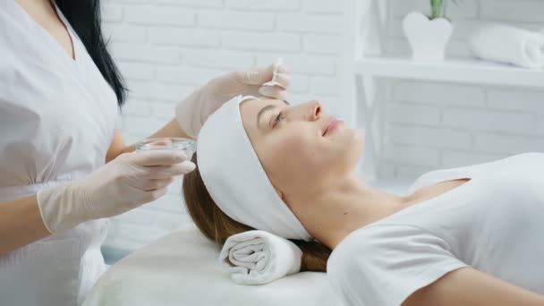 Cute woman lying on procedure for rejuvenation skin. — Stock Video