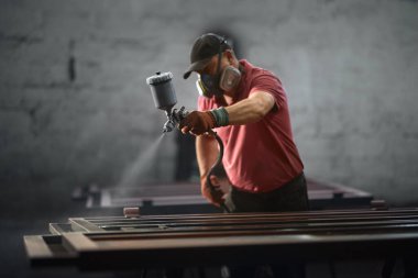 Koruyucu maskeli kıdemli adam ve çit boyayan eldivenler..