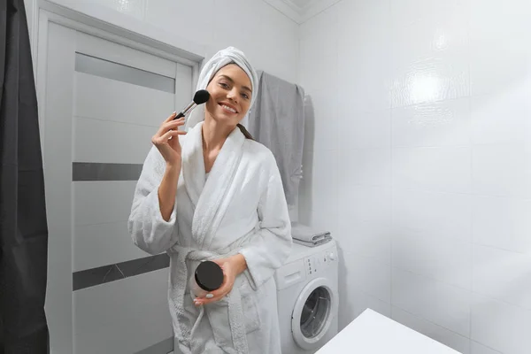 Mujer sonriente en bata haciendo maquillaje. —  Fotos de Stock