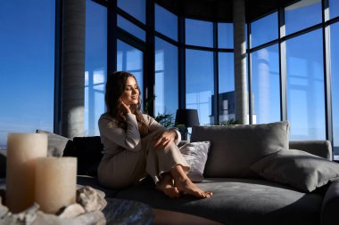 Büyüleyici bir kadın panoramik mucizelerle evde dinleniyor.