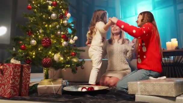 Anya lányai énekelnek közel karácsonyfa otthon — Stock videók