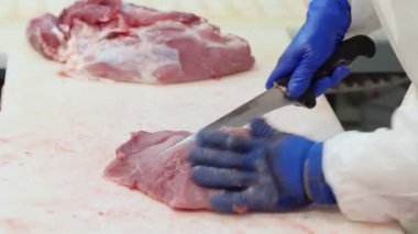 Tanımlanamayan kasap fabrika taşıyıcısında çiğ et kesiyor..