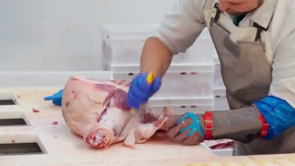 Male butcher removing sking with fat from raw meat. — Stock Video