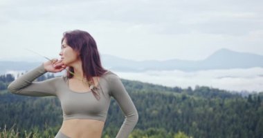 Spor elbiseli kadın doğada poz veriyor.