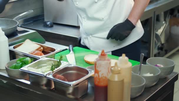 Close-up van chef koken heerlijke hamburger op keuken — Stockvideo