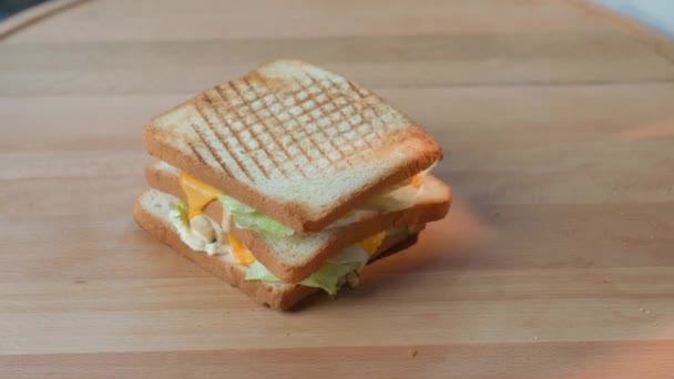 Šéfkuchař krájí vynikající sendvič na dřevěné desce — Stock video