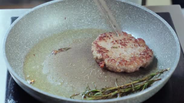 Kock stekning nötkött hamburgare på pan med olja, vitlök och rosmarin — Stockvideo