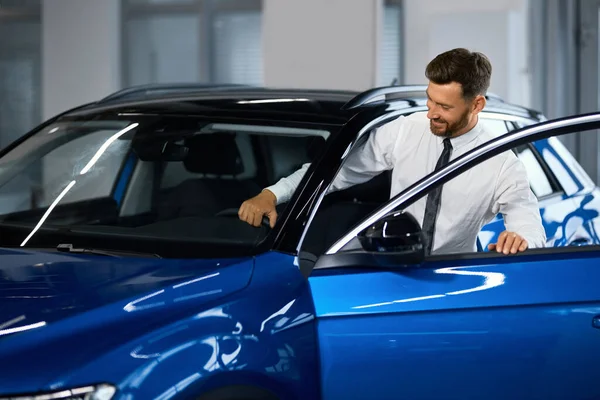 Man testing new car before making purchase at salon — Fotografie, imagine de stoc