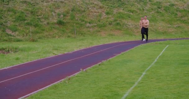 Athletic men with bare torso running outdoors — стоковое видео