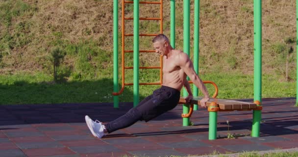 Спортивний без сорочки чоловік робить поштовхи на відкритому повітрі — стокове відео