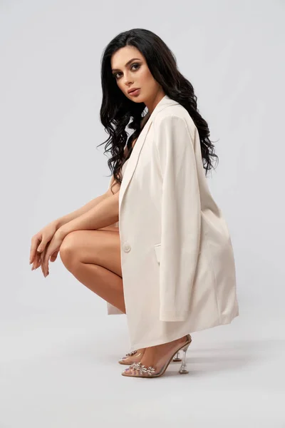 Lady in stylischer weißer Jacke und High Heels posiert im Studio — Stockfoto