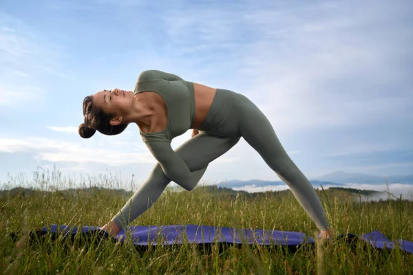 Активная женщина делает гибкие упражнения на открытом воздухе — стоковое фото