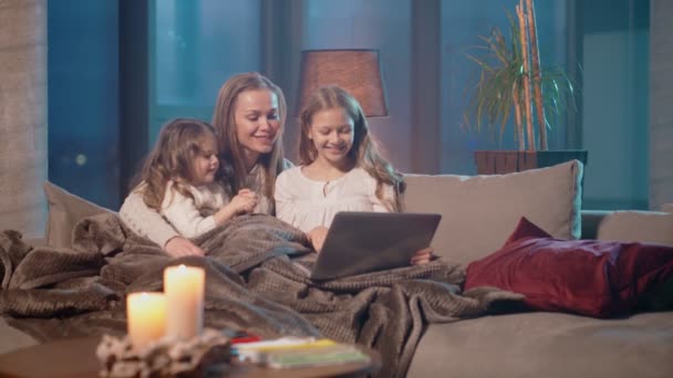 Madre con hijas que tienen videollamada en el interior del ordenador portátil — Vídeos de Stock
