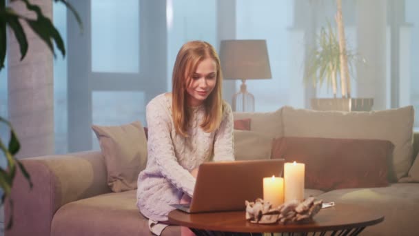 Vrouw het hebben van video oproep op laptop terwijl zitten op bank — Stockvideo