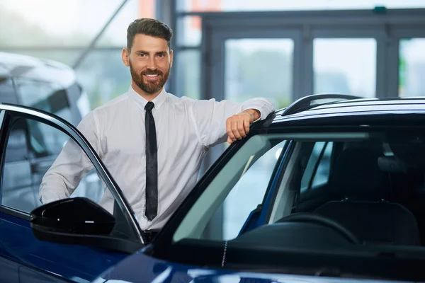 Empresario visitando salón de automóviles para elegir un vehículo nuevo — Foto de Stock