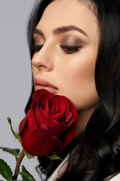 Schöne Dame mit roter Rose über grauem Hintergrund — Stockfoto