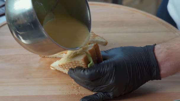 Chef en guantes poniendo queso derretido en sabroso sándwich — Vídeos de Stock