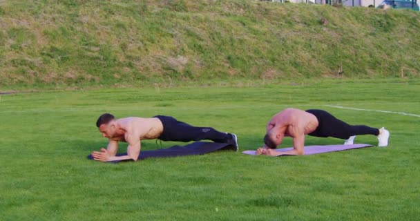 Мужчины без рубашек делают упражнения на открытом воздухе — стоковое видео