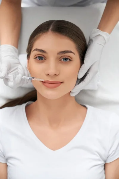 Mujer linda en camisa blanca en el procedimiento de inyección en el labio. — Foto de Stock