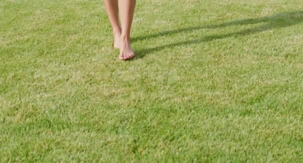 一个赤脚在草坪上行走的女人的近照 — 图库视频影像