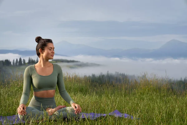 Donna che pratica la meditazione in posizione loto all'aperto — Foto Stock