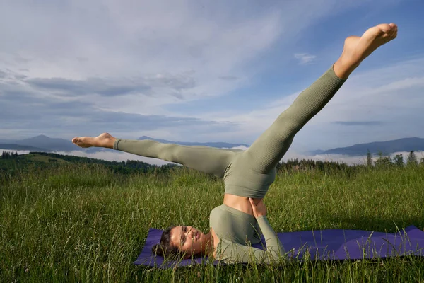 Donna in abiti sportivi che fa esercizi di yoga all'aperto — Foto Stock