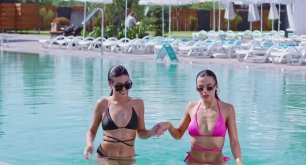 Dos mujeres caucásicas en bikini saliendo de la piscina — Vídeo de stock