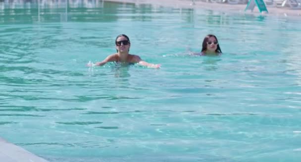 Χαλαρωμένες κυρίες με μπικίνι που κολυμπούν μαζί στην εξωτερική πισίνα — Αρχείο Βίντεο