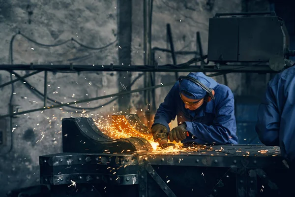 Dělník vyrábějící vrata ze železa v garáži. — Stock fotografie